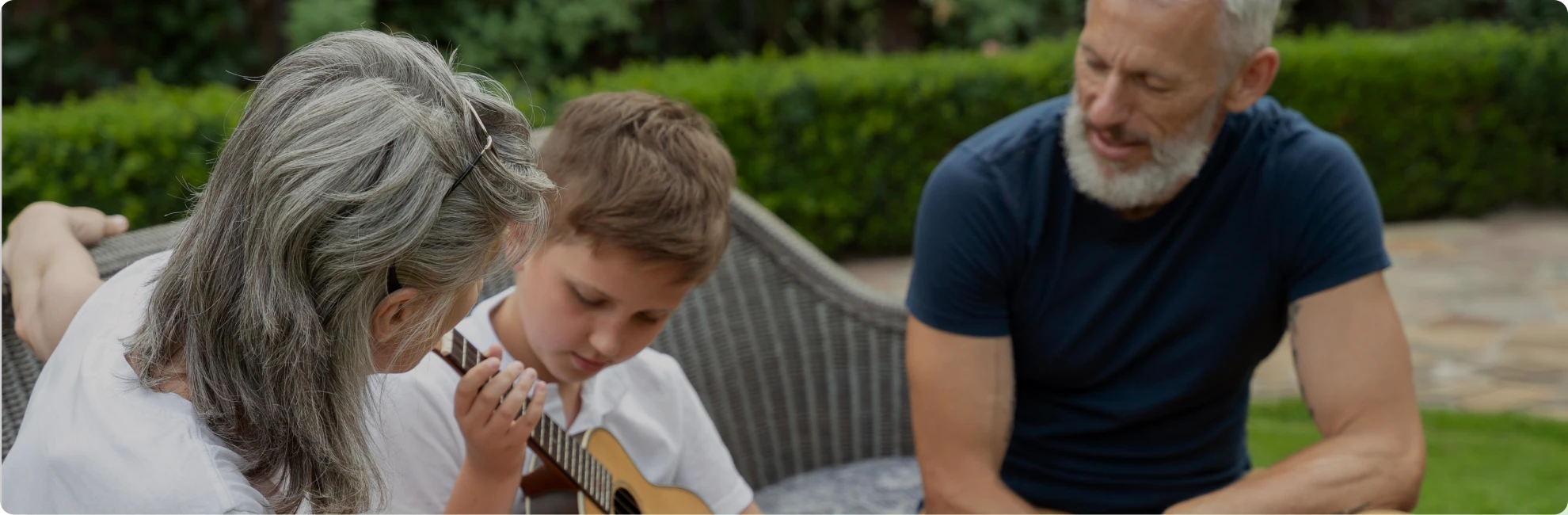 grandparents with child playing guitar